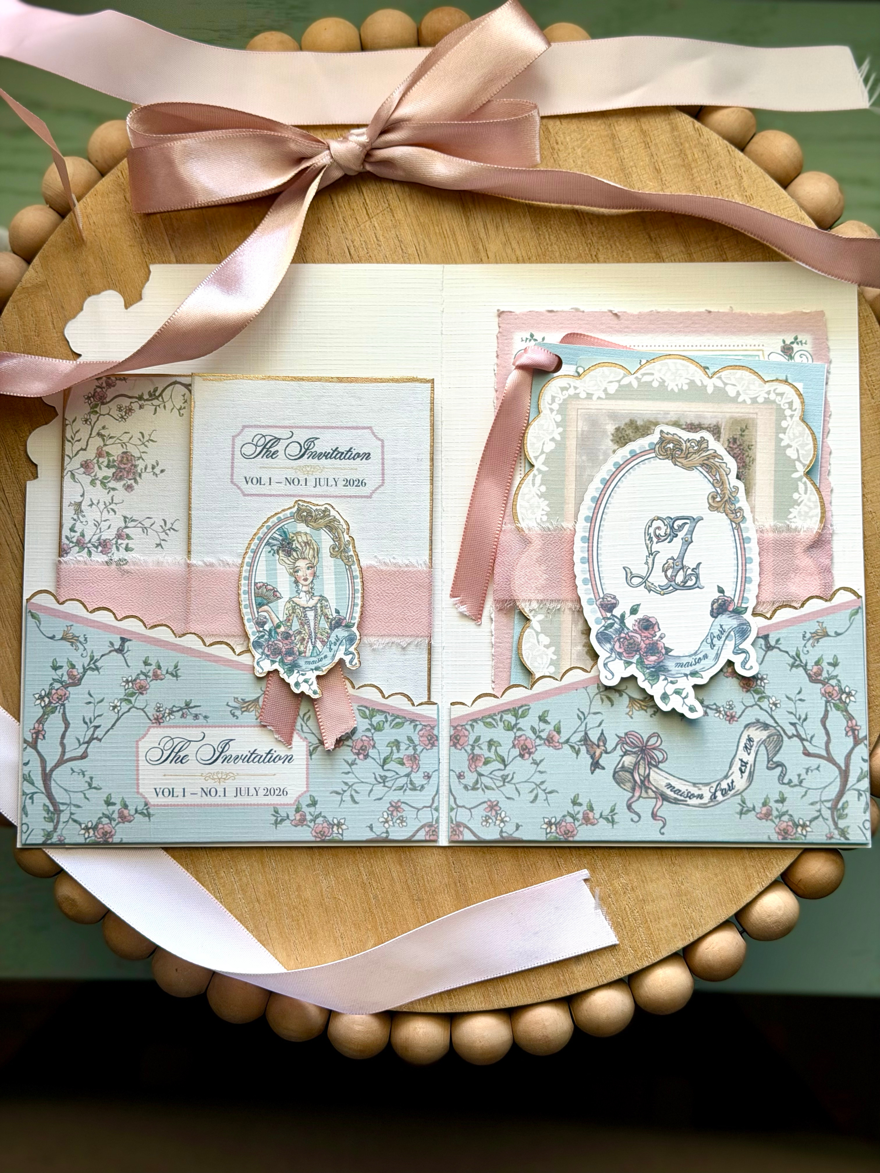 Vintage-style invitation card with decorative elements on a wooden surface.